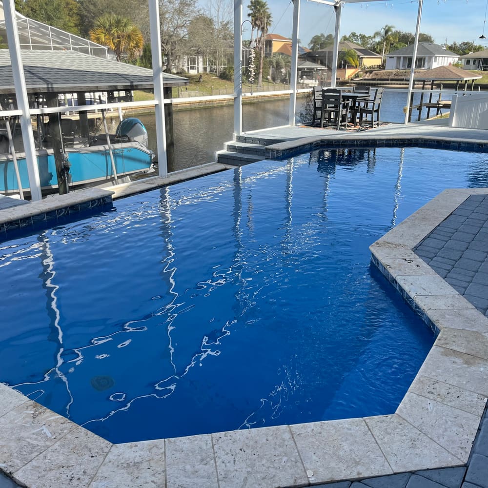 Finished dark-blue pool on a screened lanai overlooking a Palm Coast canal