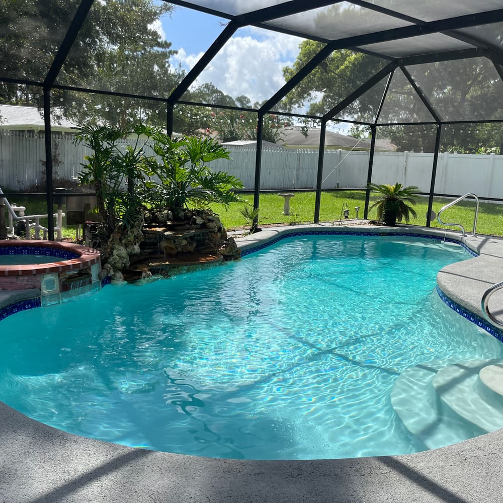Freeform pool and spa with a natural rock waterfall feature