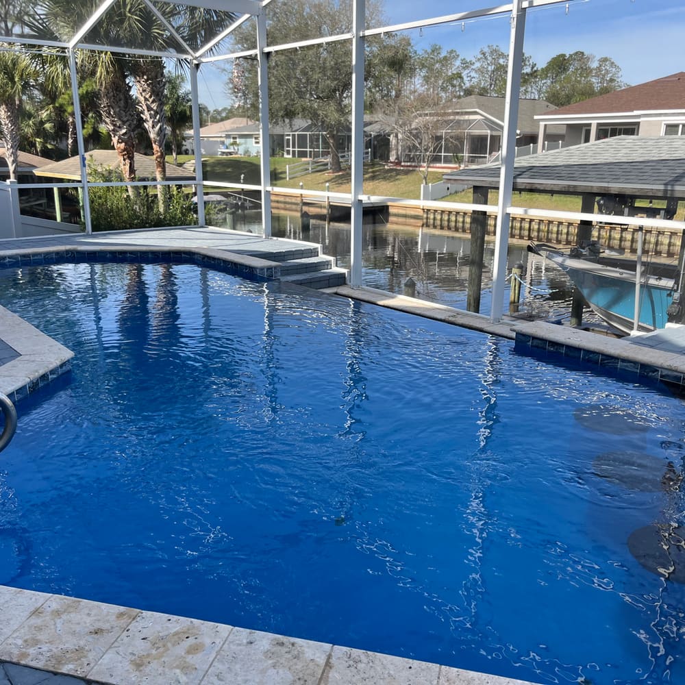 Finished pool on a screened lanai with canal and boat dock views